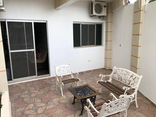 a patio with two chairs and a table and a table and chairs at NatuCenter Hospedaje in Puerto Presidente Franco