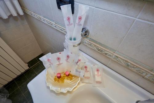 a bathroom with a sink with toothbrushes and candy at Hotel Riviera dei Dogi in Mira