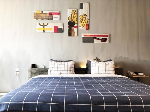 a bedroom with a bed with a blue plaid blanket at the AMARTYA in Yogyakarta