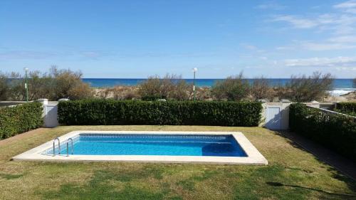 Playaにあるprimera línea de la playa de oliva con jardín y piscina.の海を背景にしたスイミングプール