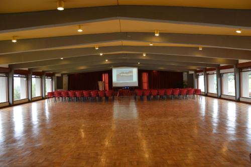 a large room with a stage with chairs and a screen at D'Acosta Hotel Sochagota in Paipa