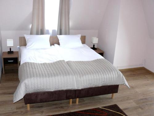 a large bed in a bedroom with two night stands at Victoria in Międzyzdroje