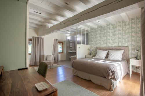 ein Schlafzimmer mit einem Bett und einem Schreibtisch in einem Zimmer in der Unterkunft La Barbotiere in Chevannes