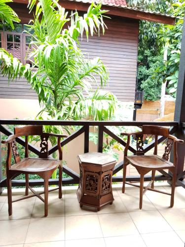 two chairs and a table on a balcony with a plant at Ombak Dive Resort Perhentian Island in Perhentian Island