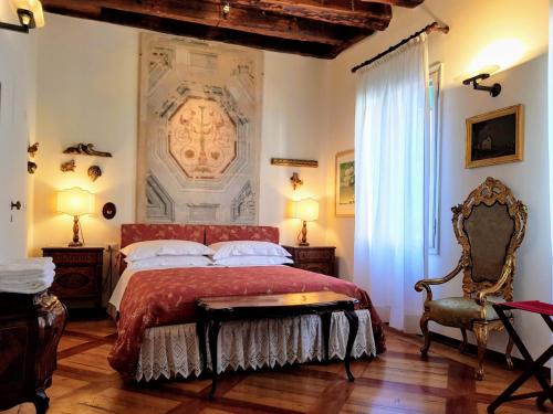 a bedroom with a large bed with a red bedspread at Palazzo Morosini Brandolin Dimora Romantica in Venice