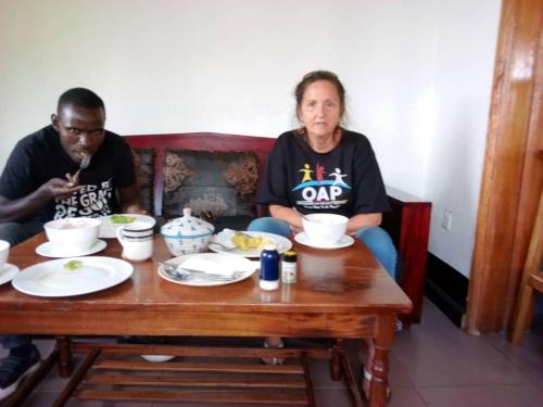a man and a woman sitting at a table at Rena Akasha Establishments in Kyenjojo