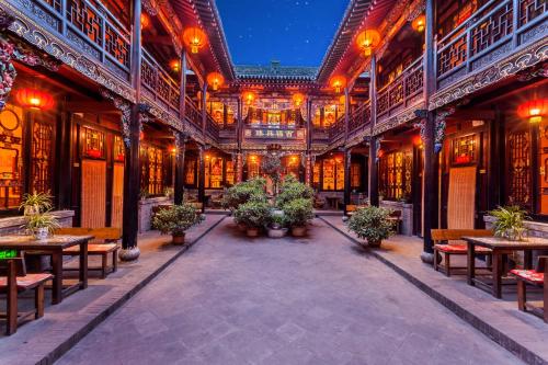 an old building with tables and benches and lights at Pingyao Harmony Hotel in Pingyao