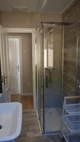 bagno con doccia in vetro e lavandino di PortoHouse a Portomarin