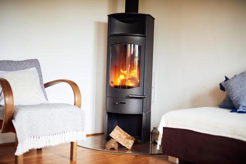 a wood stove in a room with a bed and a chair at Weingarten Lodge in Winten
