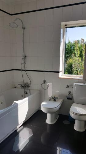 ein Badezimmer mit Toilette, Badewanne und Waschbecken in der Unterkunft Villa spacieuse proche de L'océan in Vila Praia de Âncora