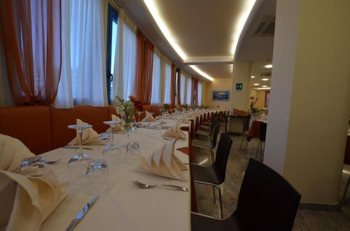 a long dining room with a long table and chairs at Hotel Cristallo in Lignano Sabbiadoro
