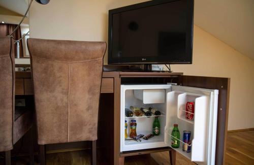 a small refrigerator with a television on top of it at Hotel M in Podgorica