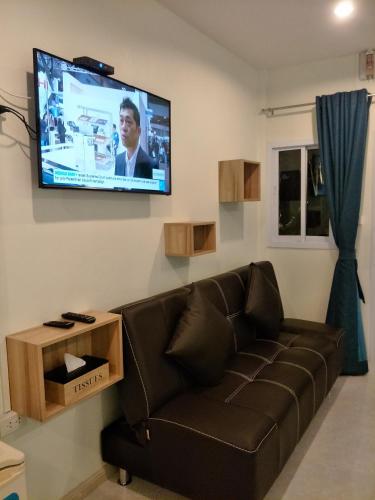 a living room with a couch and a flat screen tv at BeauBo Beach in Baan Tai