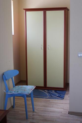 a blue chair sitting in front of a door at Vila Meteor in Cluj-Napoca
