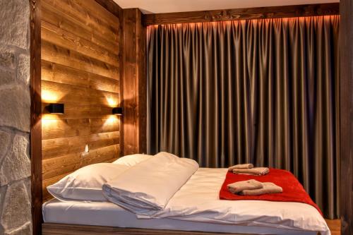 a bedroom with a bed with white sheets and a red blanket at 4Roses Apartments in Smokovce