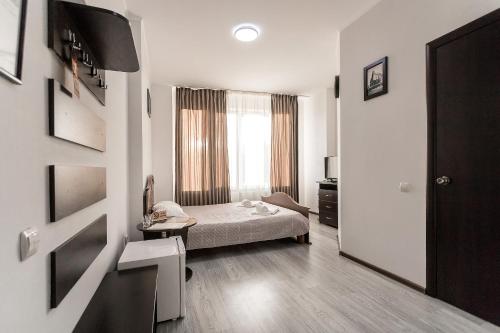 ein Hotelzimmer mit einem Bett und einem Fenster in der Unterkunft Sunlit in Iwano-Frankiwsk