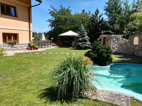 a backyard with a swimming pool and a house at Pension Král in Jablonec nad Nisou