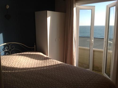 a bedroom with a bed and a view of the ocean at Angels Corner, Ventnor Bay in Ventnor