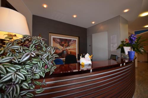 a reception desk in a lobby with a plant at Hotel Cristallo in Lignano Sabbiadoro