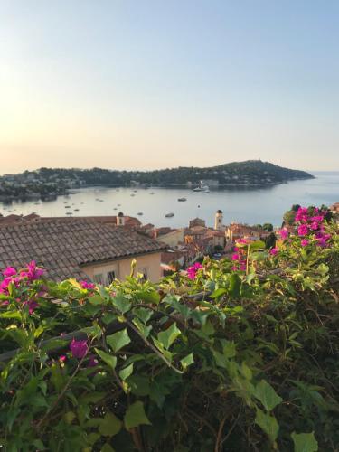 vistas a una ciudad con flores rosas en La Barmassa, en Villefranche-sur-Mer