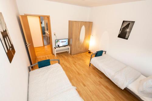 uma sala de estar com duas camas e uma televisão em AVR Apartment HOF 11 em Bremerhaven