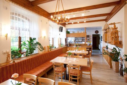 a restaurant with tables and chairs in a room at Landhaus Bergidyll in Bärenstein