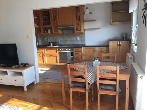 a kitchen with a table and chairs and a television at Gold in Sopron