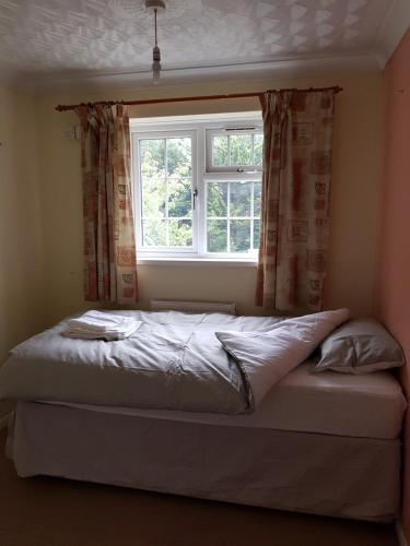 een bed in een slaapkamer met een raam bij Spacious Swindon 5 bedroom house - sleeps up to 10 in Swindon