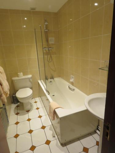 a bathroom with a tub and a toilet and a sink at The Bay Horse Hotel And Restaurant in Ulverston