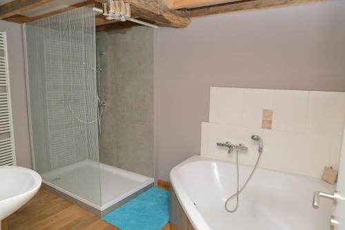 La salle de bains est pourvue d'une douche, d'une baignoire et d'un lavabo. dans l'établissement Gîte Au Coeur de Champlon, à Champlon