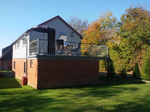 a house with a balcony on top of a building at Haus Königsstieg in Struckum