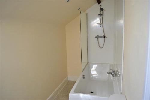 a white bathroom with a shower and a sink at The Old Bottle Store - 2 Double Bedrooms, 2 Bathrooms, St Ives, Cambridgeshire in St. Ives