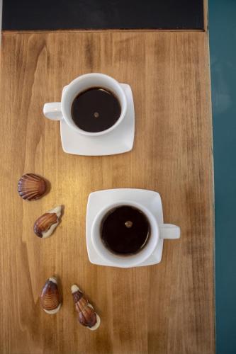 two cups of coffee sitting on a wooden table at DesertB in Giv'ot Bar
