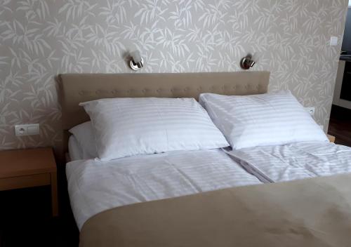 a bed with white sheets and pillows in a bedroom at Štrbské Pleso rezidencia Oliver - apartmán 16A in Štrbské Pleso