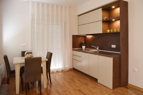 Una cocina y un comedor con una mesa y un fregadero. en Vrnjacka Idila, en Vrnjačka Banja