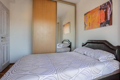 a bedroom with a bed and a door with a mirror at Old town Beauty Apartment with great view in Podgorica