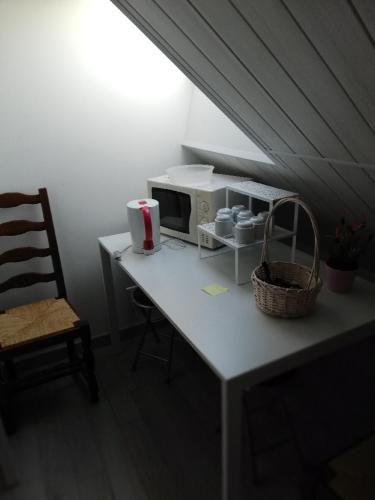 une cuisine avec une table, un four micro-ondes et une chaise dans l'établissement les fermiers, à Giremoutiers