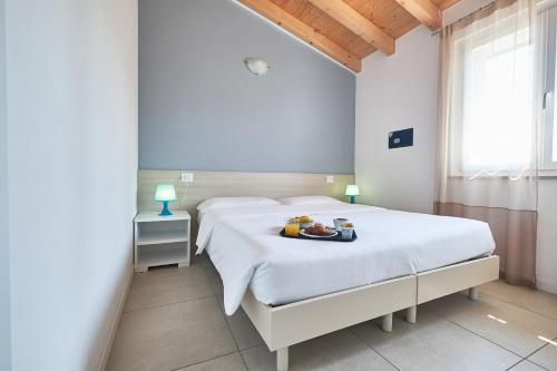 a bedroom with two beds with a tray of fruit on it at Villaggio Turistico Lugana Marina in Sirmione