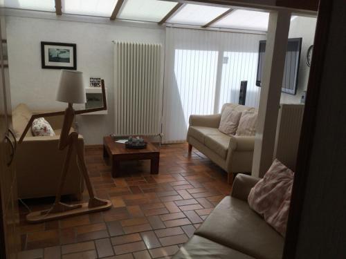 ein Wohnzimmer mit einem Sofa und einem Tisch in der Unterkunft Mittelalterliches Fachwerkhaus am Diebesturm - klimatisiert- in Bad Sooden-Allendorf
