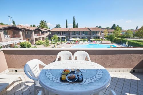 a table with a plate of food on top of a balcony at Villaggio Turistico Lugana Marina in Sirmione