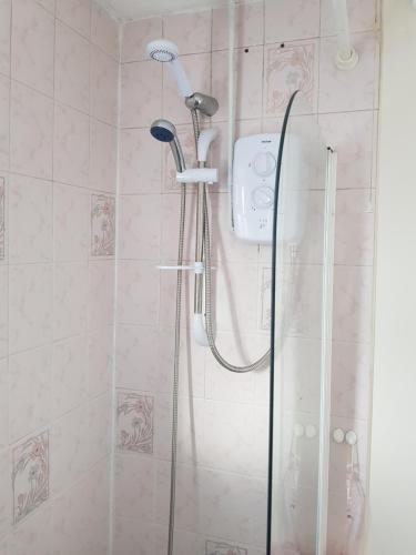 a shower with a shower head in a bathroom at Spacious Swindon 5 bedroom house - sleeps up to 10 in Swindon