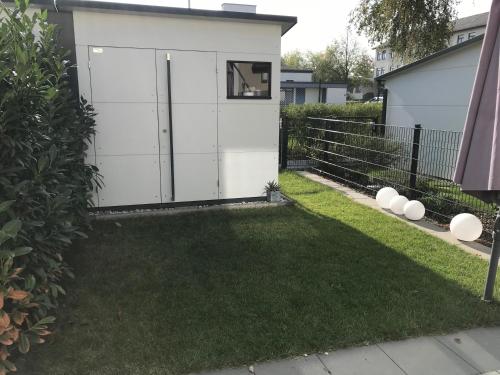 a small white shed with a grass yard at Ferienhaus Alte Kaserne in Andernach