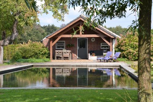 a house with a pool in front of it at Vijverhoef in Ulicoten