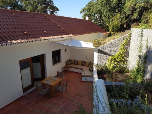 a patio of a house with a couch and a table at Casinha Laranja in Monchique