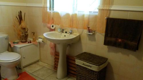 uma casa de banho com um lavatório e um WC em Beth-El em Mossel Bay