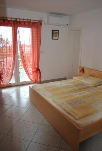 a bedroom with a bed and a large window at Villa Antonia in Klenovica