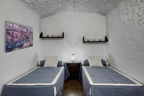 Cueva Alcázar في Gorafe: غرفة بسريرين في غرفة