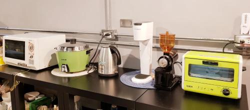 a kitchen counter with a microwave and appliances on it at MILU Backpacker Hostel in Puli