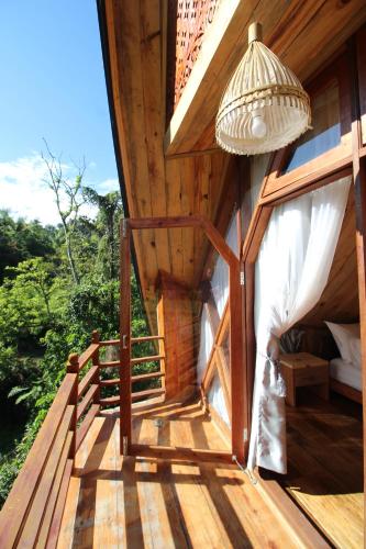 a porch of a house with a bed and a lamp at Padi Ecolodge in Bukittinggi