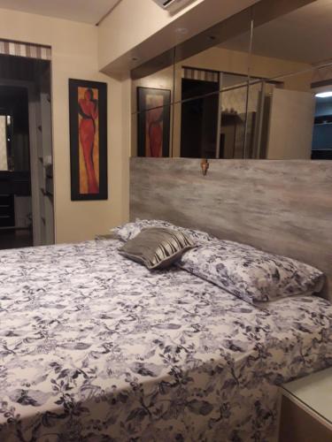 a bedroom with a large bed with a white and black blanket at Maravilhoso Apartamento na Beira Mar in Fortaleza